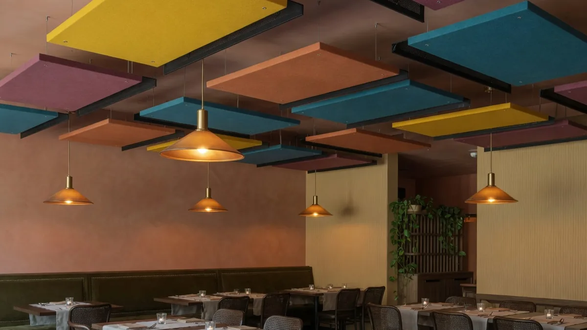 Salle de restaurant équipée d'îlots acoustiques colorés au plafond
